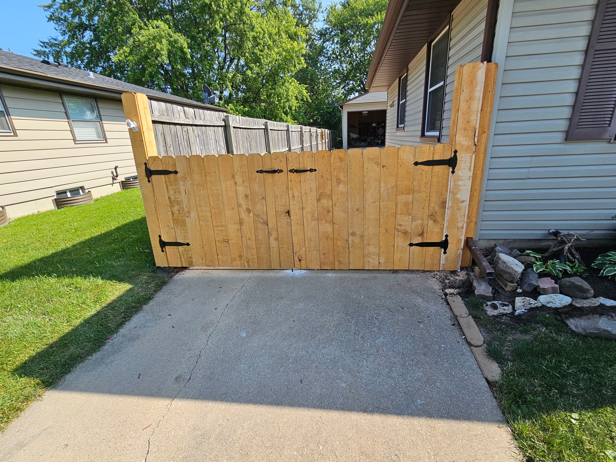 A cedar fence and gate across a residential driveway